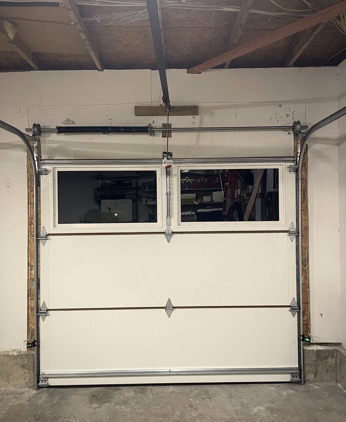 A garage door hung in its track with the framing still exposed